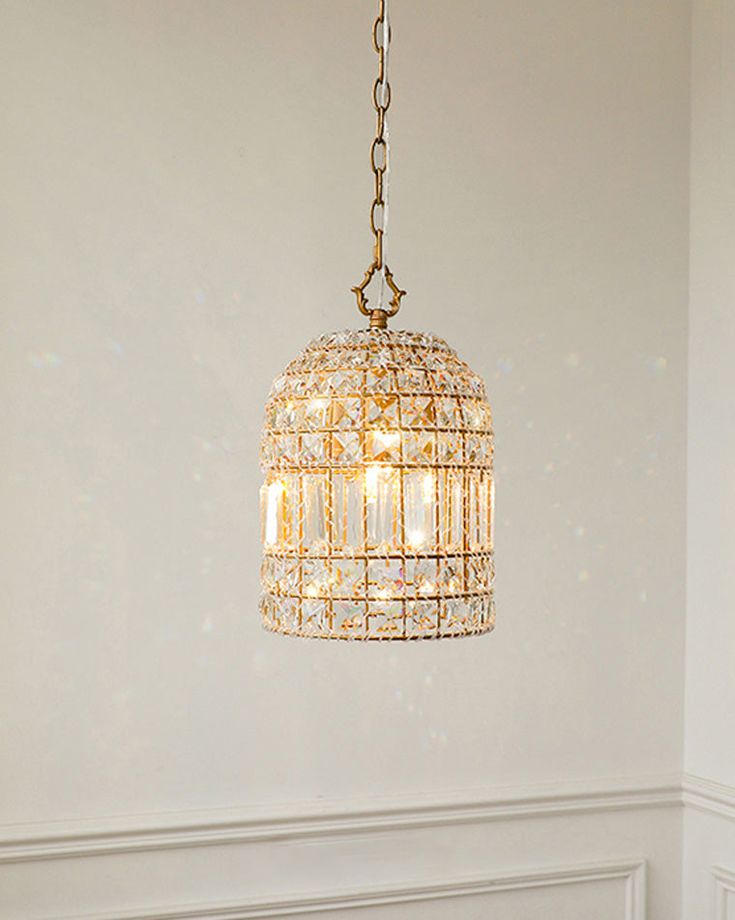 a chandelier hanging from the ceiling in a room with white walls and flooring