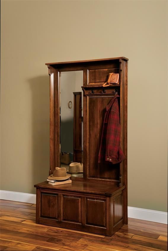 a wooden bench sitting in front of a mirror on top of a hard wood floor