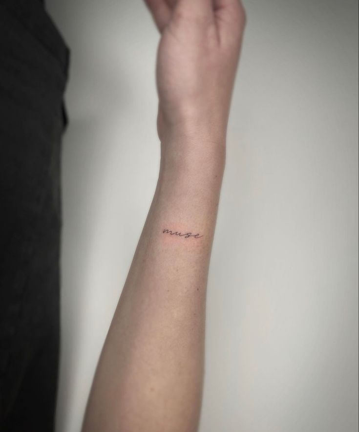 a person's arm with a small tattoo on the left side of their arm