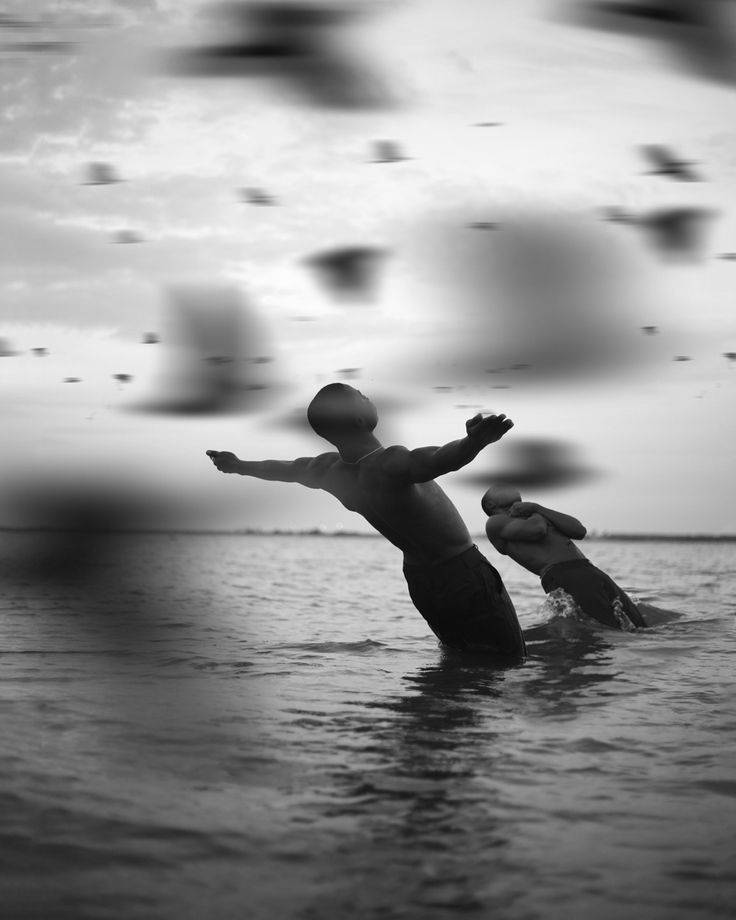 two people are in the water with their arms outstretched