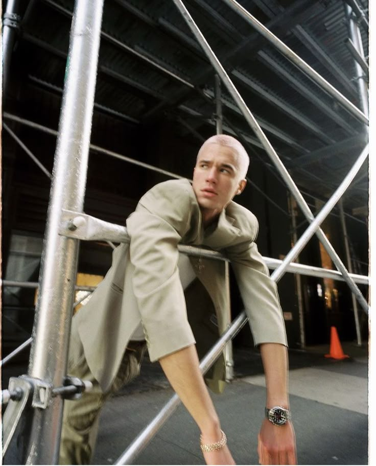 a man leaning on the side of a metal structure