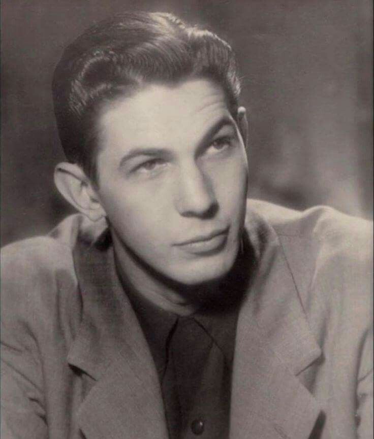 an old black and white photo of a man in a suit looking at the camera