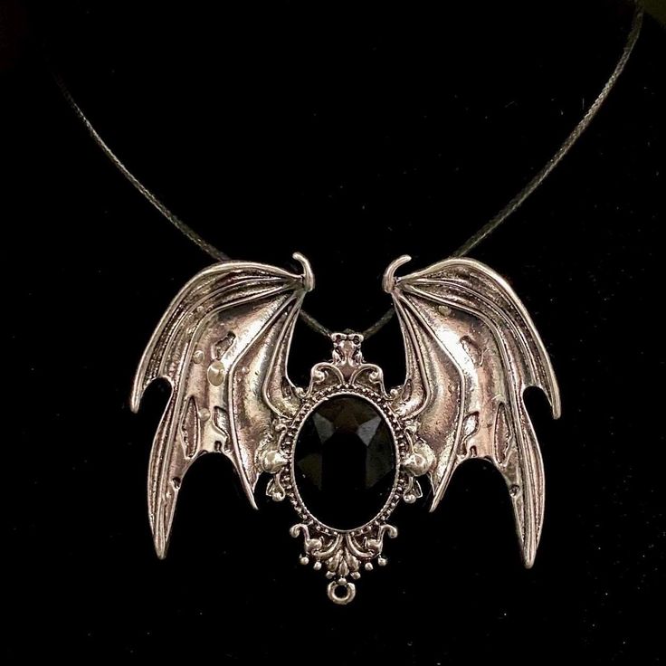 Please read descriptions thoroughly for sizes and materials. This is an eye catching large silver metal pendant featuring silver bat wings, with a black faceted glass gem in the center. It is hung from a black faux leather woven waxed cord that is 19 1/2" long, with silver chain and a silver lobster claw clasp. * Also available on a 18" 20" 24" or 30" silver stainless steel snake chain.  The pendant is just over 3" wide and just under  2 1/2" long. Make sure to check out my shop for more hair pins, jewelry, accessories, and all sorts of fun stuff! Bat Necklace, Large Black Bat, Goth Necklace, Gothic Necklace, Wing Necklace, Bat Wing, Silver Black Bat, Vampire Jewelry, Bat Jewelry, Vampire Necklace Please note: I am not responsible for any items lost or damaged in the mail. Please double ch Jewelry Vampire, Vampire Necklace, Vampire Jewelry, Bat Jewelry, Bat Necklace, Goth Necklace, Gothic Necklace, Bat Wing, Wing Necklace