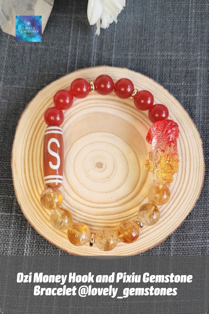 a plate with some beads on it next to a flower and a glass vase filled with flowers