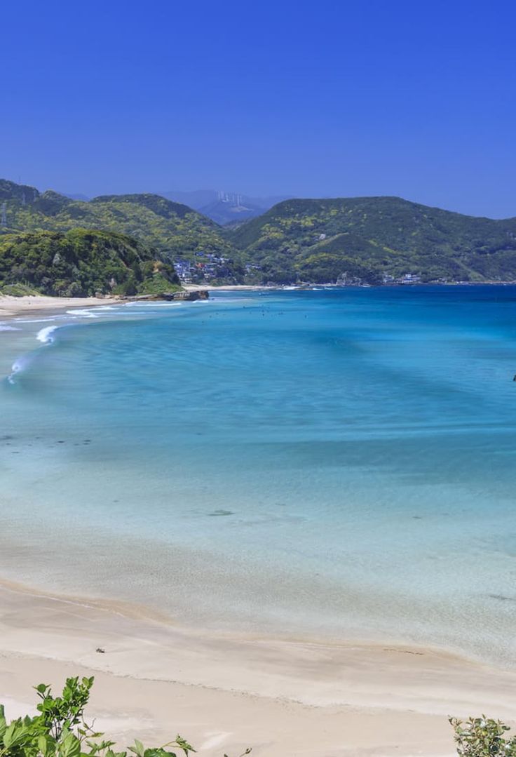 the water is crystal blue and clear with white sand on the beach near to it