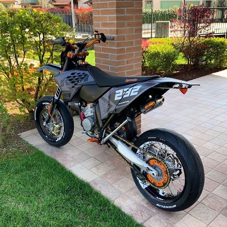 a dirt bike parked on the side of a brick building in front of a house