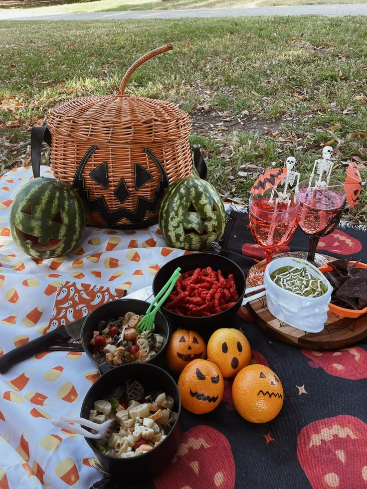 a table topped with bowls filled with food next to watermelons and pumpkins