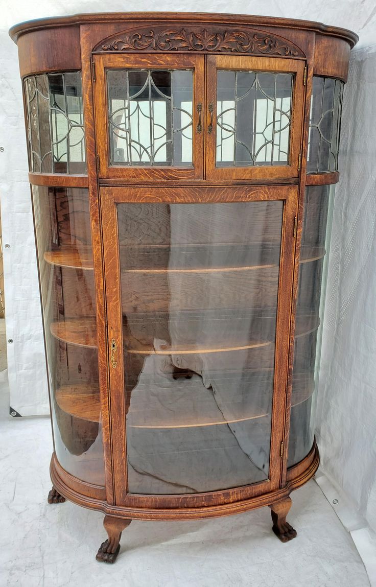 an old wooden display cabinet with glass doors and wood trimmings on the sides