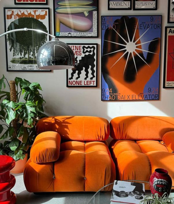 a living room with orange couches and pictures on the wall