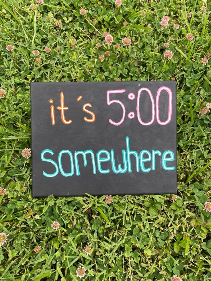 a sign that says it's 500 somewhere on the grass with flowers in the background