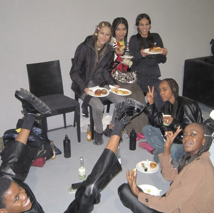 a group of women sitting around each other with plates of food in front of them