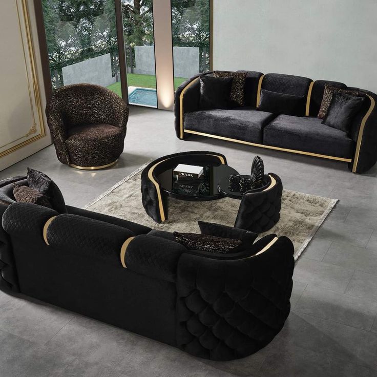 a living room filled with black couches and chairs on top of a carpeted floor