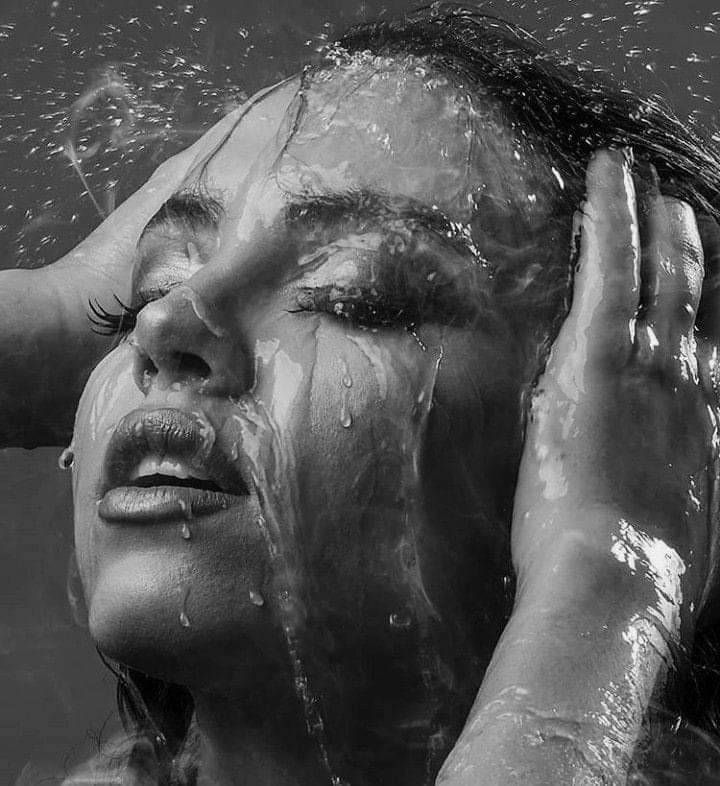 a woman covered in water with her hands on her head