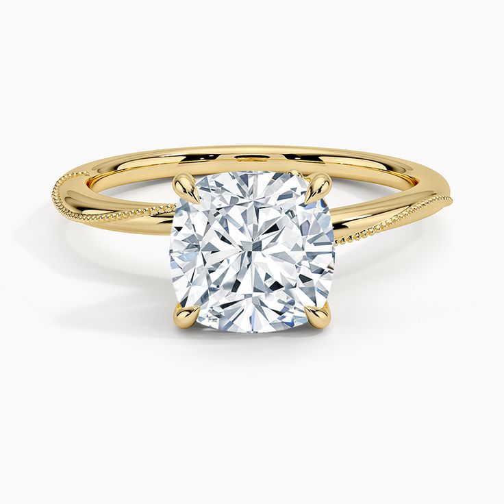 a yellow gold engagement ring with a cushion cut diamond