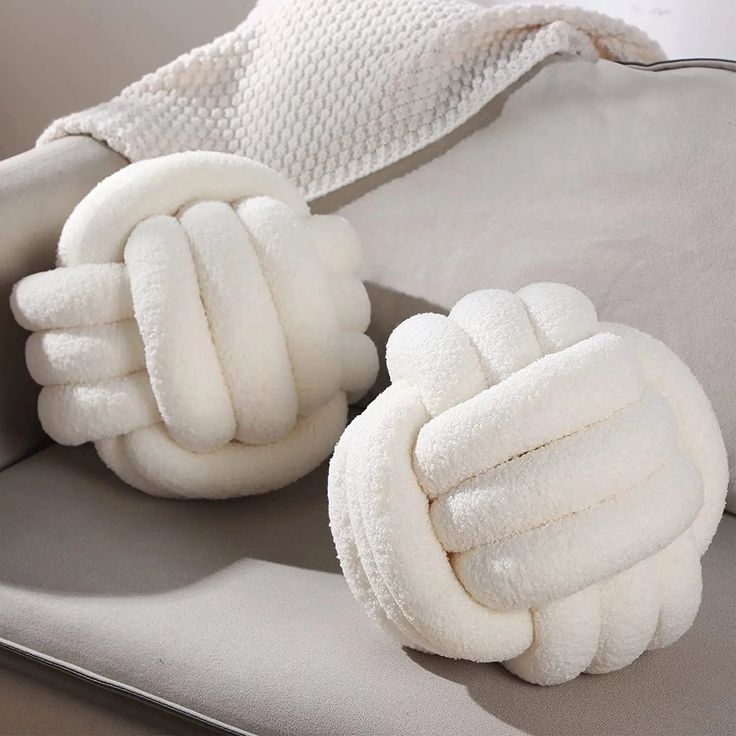 two white gloves sitting on top of a couch