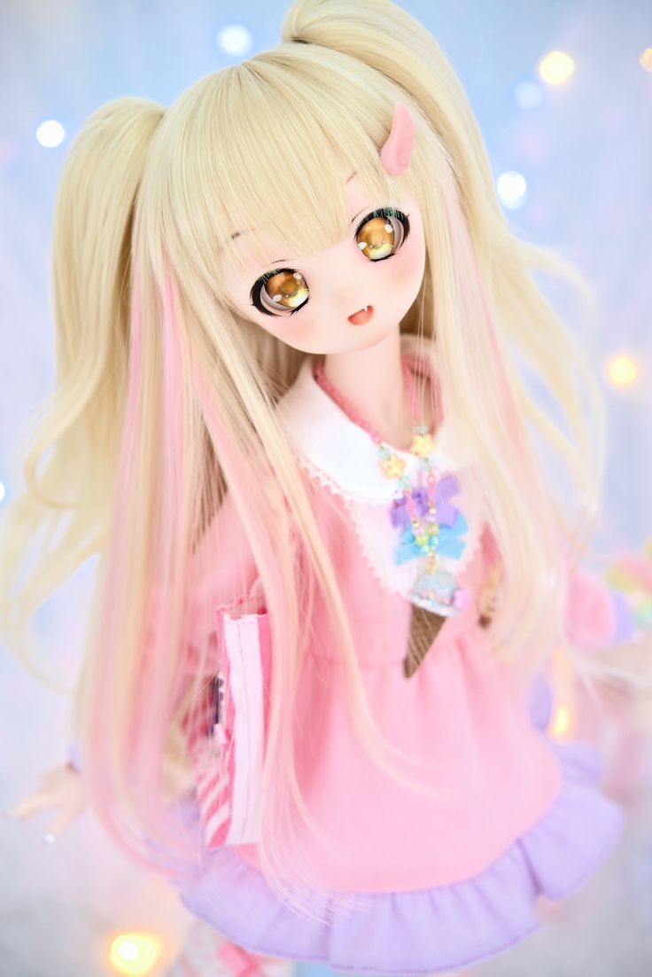 a doll with long blonde hair wearing a pink dress