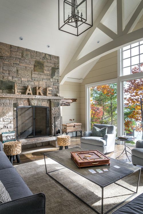 a living room filled with furniture and a fire place in front of a large window