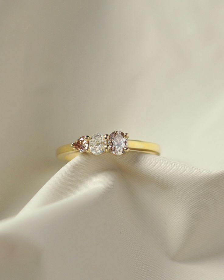 three stone diamond ring on white fabric