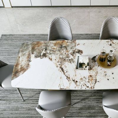 a marble dining table with four chairs and a bottle of wine on the top in front of it