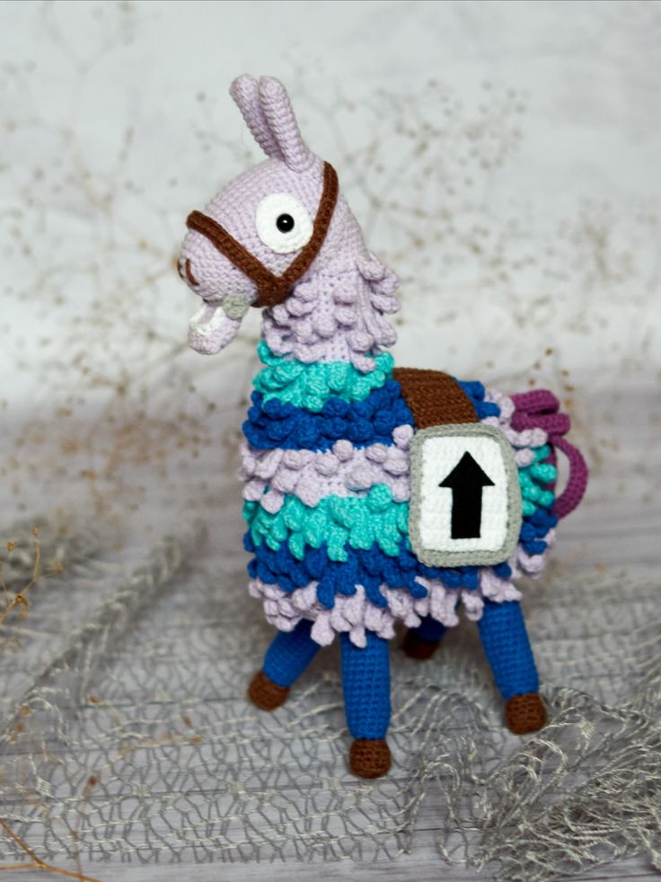 a crocheted llama with an arrow on it's back is shown