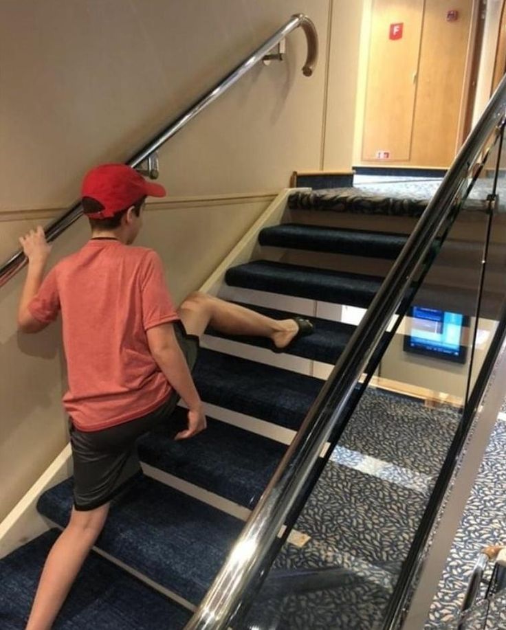 a young boy is climbing up the stairs on his skateboard and holding onto an escalator