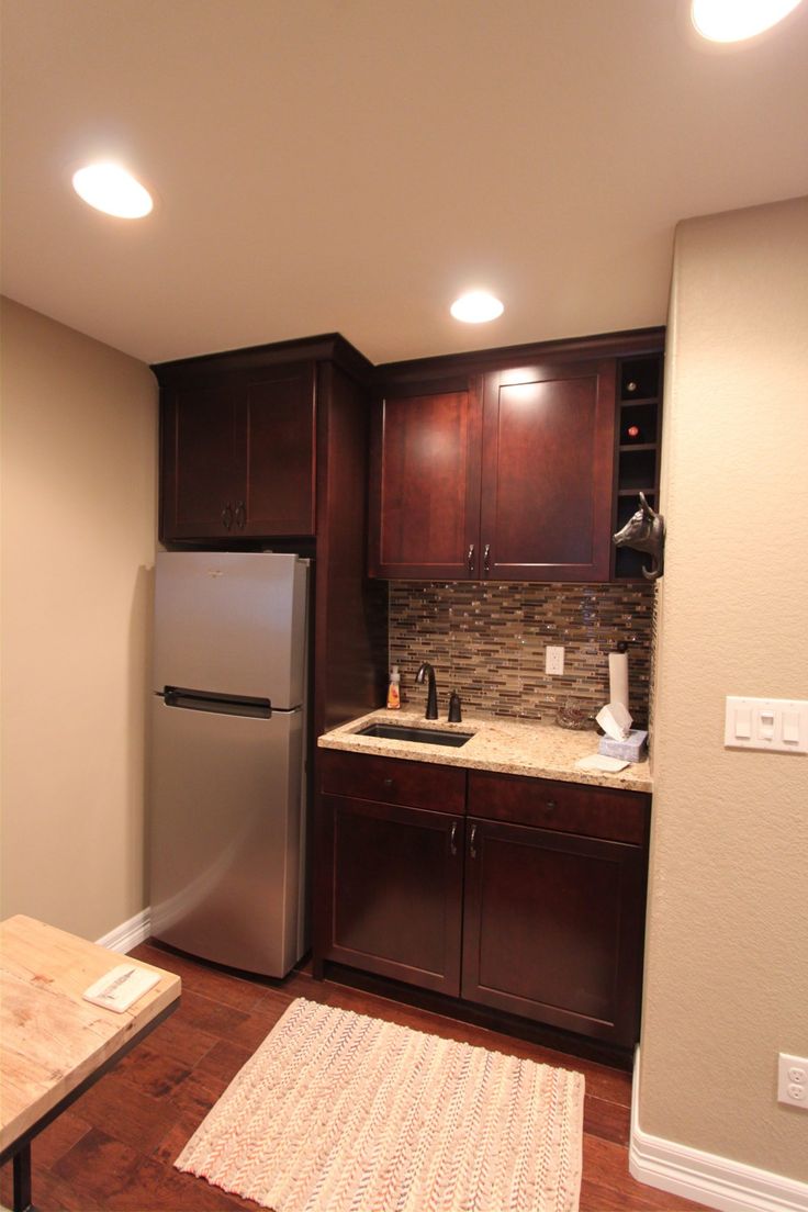 a kitchen with wooden cabinets and stainless steel refrigerator freezer next to a counter top