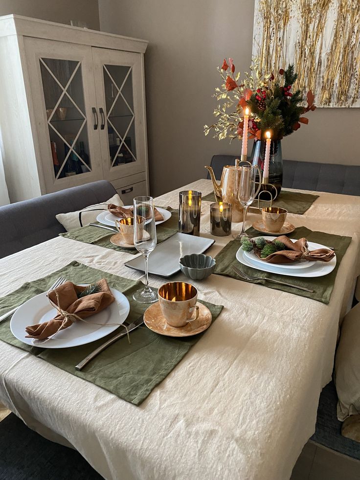 a dining room table set with plates and place settings