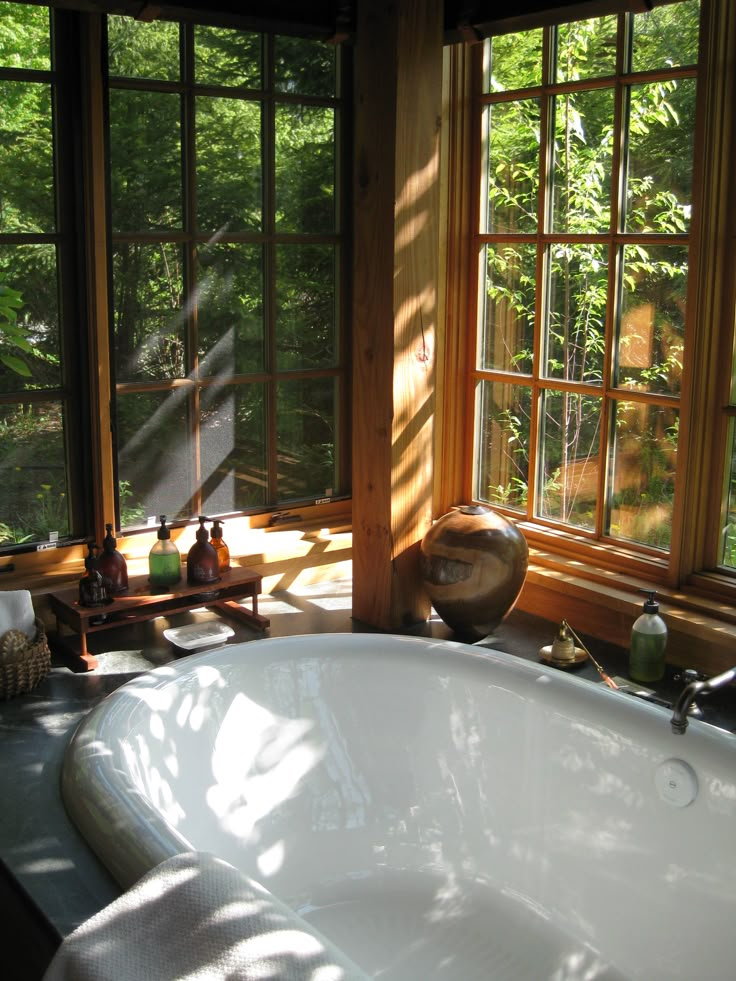 a large white bath tub sitting next to two windows