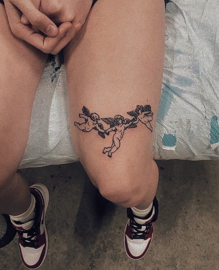 a woman's legs with tattoos on them sitting on the floor next to a bed