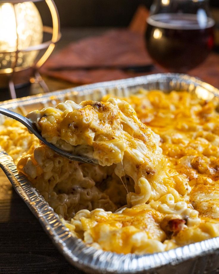 a spoonful of macaroni and cheese being lifted from a casserole dish