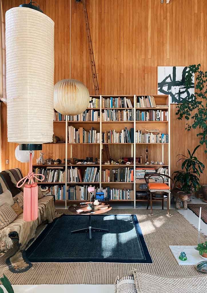 a living room filled with furniture and bookshelves next to a wall full of books