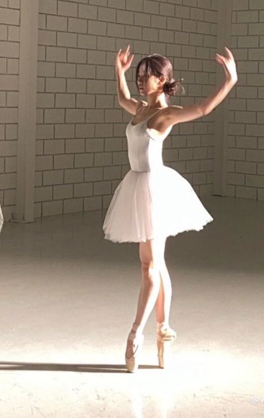 a woman in a white dress is dancing