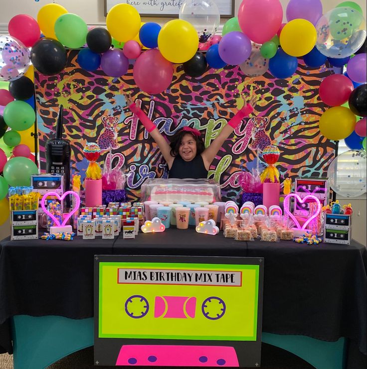 a woman standing in front of a table with balloons