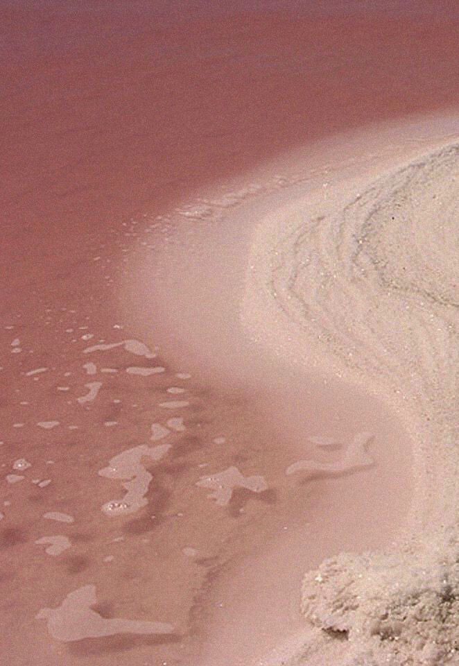 an airplane is flying over the sand and water at low altitude in the desert area