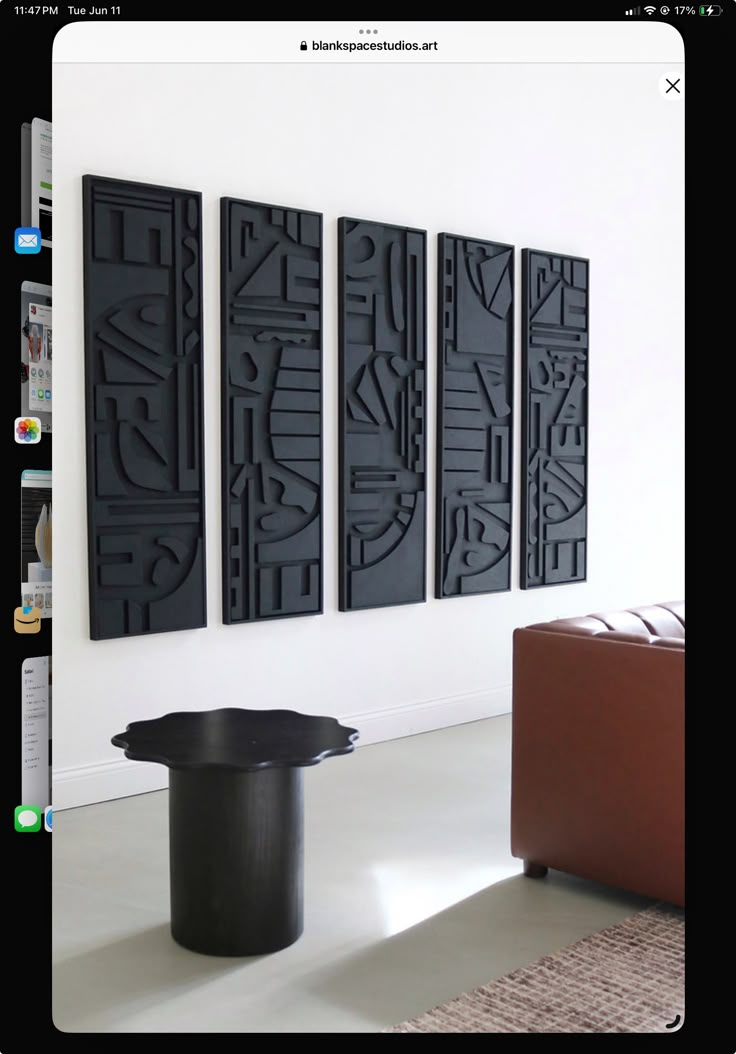 a room with three black art pieces hanging on the wall