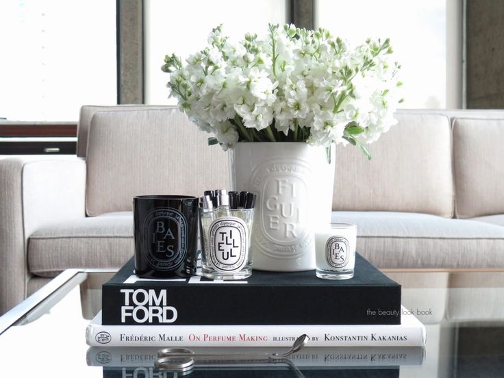 a table topped with books and vases filled with flowers on top of each other