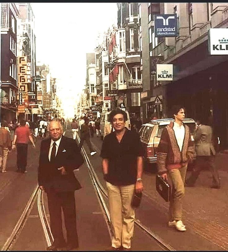 two men walking down the street with other people