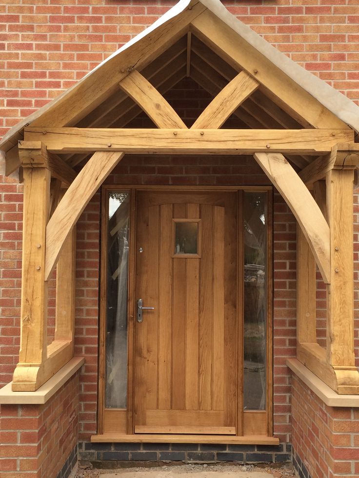 a wooden front door sitting next to a brick building