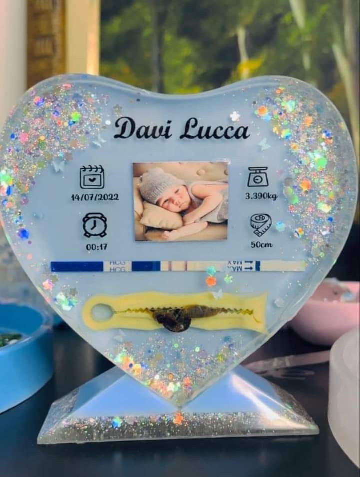 a heart shaped photo frame with a baby in it on top of a blue table