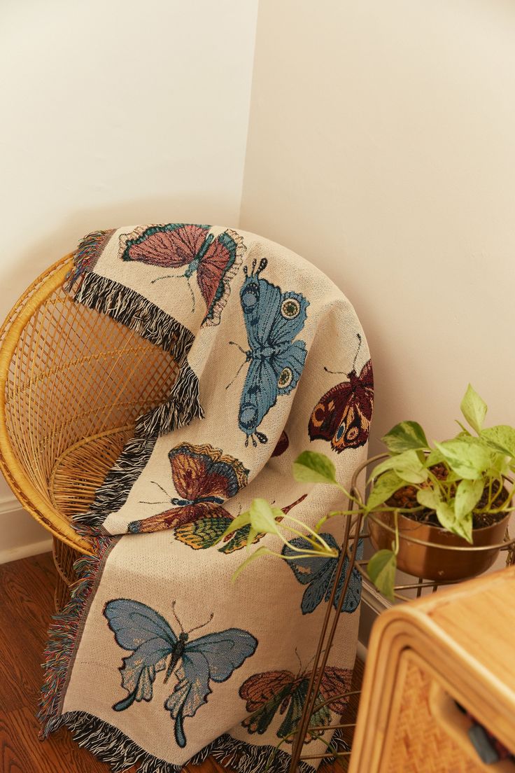 a chair sitting next to a potted plant on top of a hard wood floor