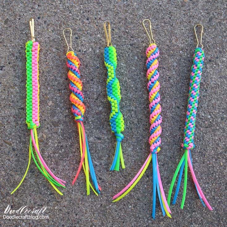 four different colored parasols are lined up on the ground, one has a hook