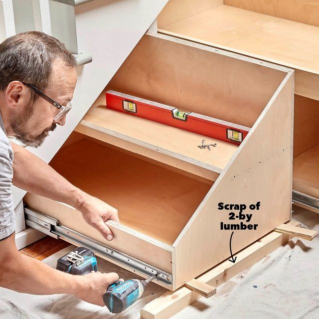 a man is working on some drawers in the kitchen, with tools and materials needed to assemble them