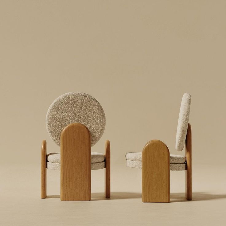 two chairs with wooden legs and white upholstered cushions, one in the shape of a circle