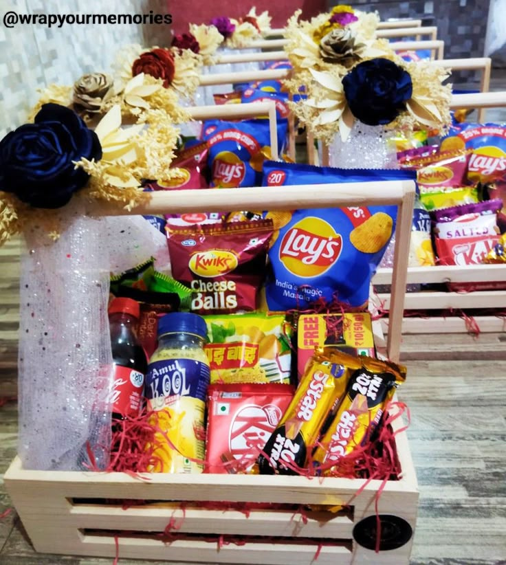 two wooden crates filled with candy and candies on top of a table next to flowers