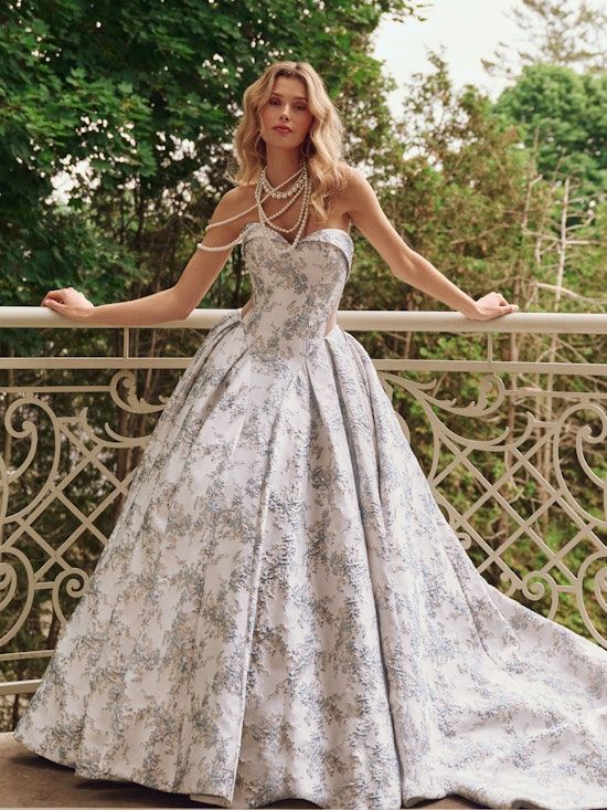 a woman in a dress standing on a balcony