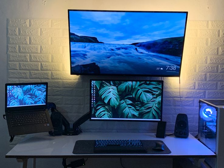 three computer monitors sitting on top of a desk