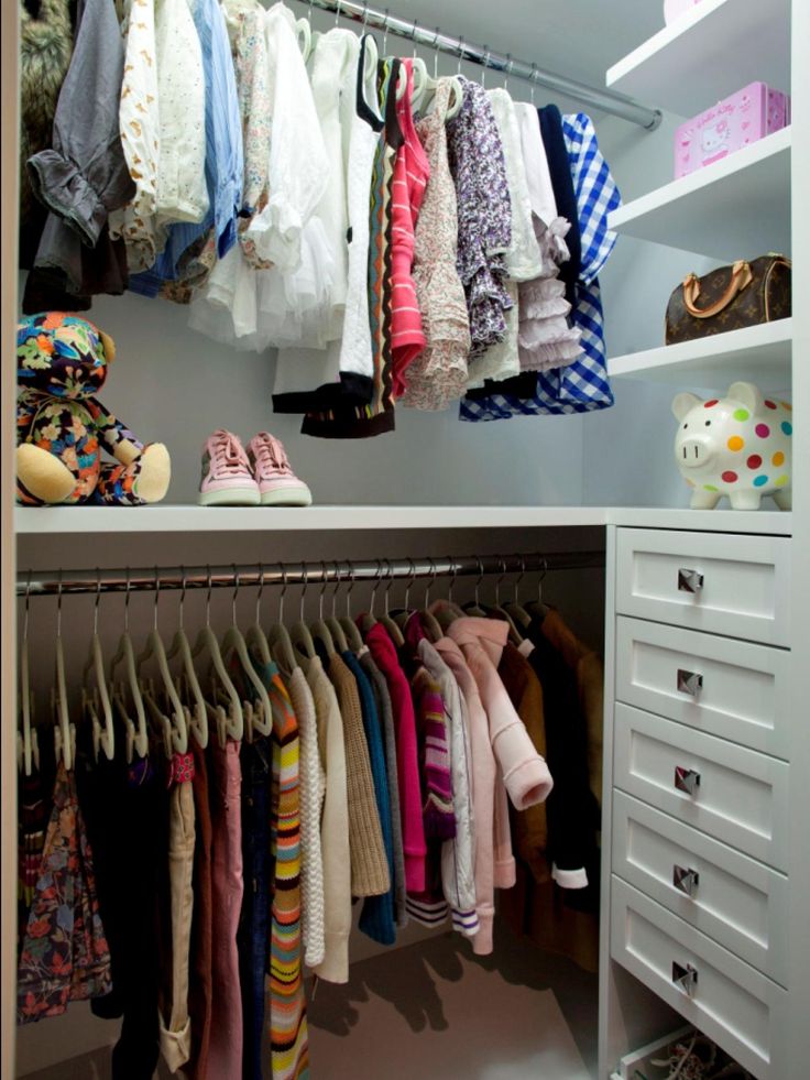 an organized closet with clothes and shoes hanging on the rails, drawers, and shelves