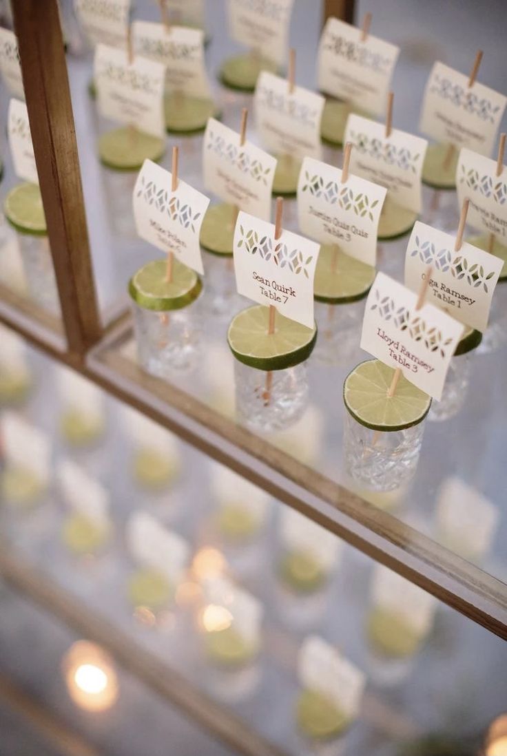 there are many small cups on the table with toothpicks in them and place cards