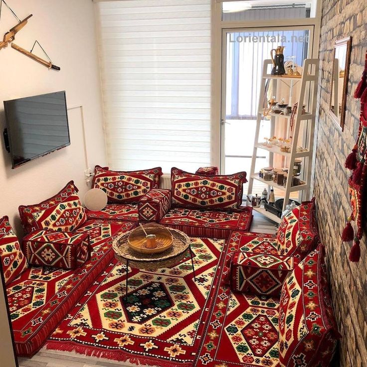 a living room filled with red couches and rugs