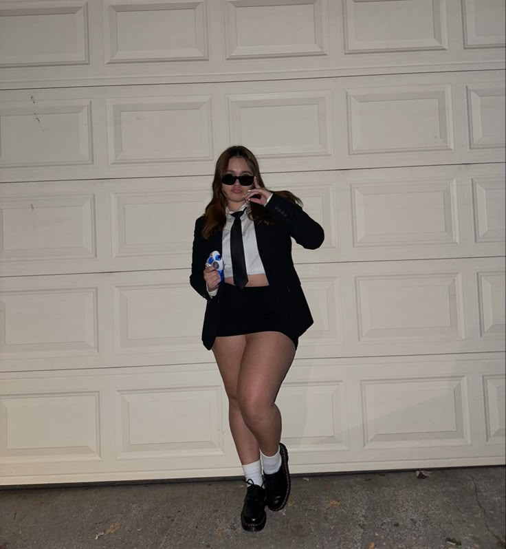 a woman dressed in black and white poses for the camera while holding a bottle of water